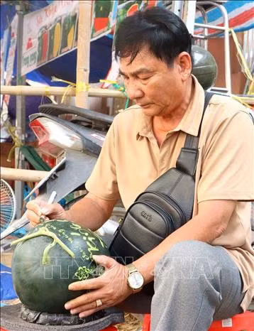 Thợ khắc thư pháp trang trí cho những quả dưa hấu chưng trong ngày Tết.