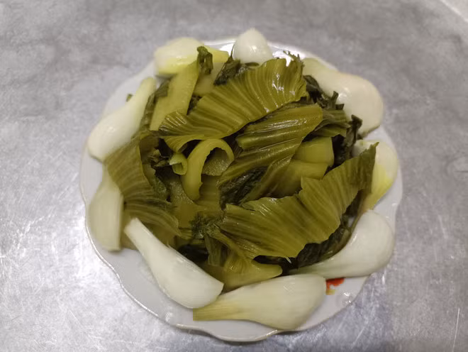 Đĩa dưa hành muối cũng là một món ăn truyền thống trong ngày Tết để cân bằng với các món nhiều dầu mỡ. (Ảnh: PV/Vietnam+)