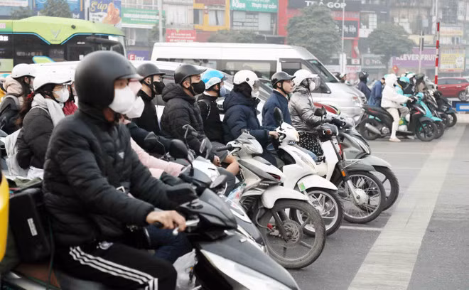 Người dân chấp hành hiệu lệnh đèn tín hiệu giao thông tại tuyến đường Khuất Duy Tiến - Nguyễn Trãi. (Ảnh: Phạm Kiên/TTXVN)