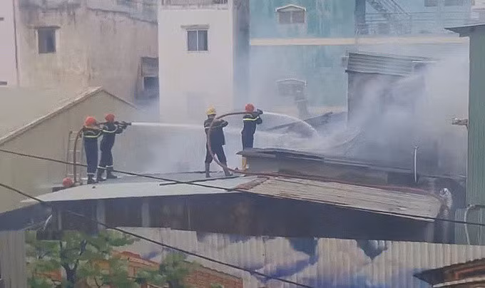 Lính cứu hỏa kéo vòi rồng lực dập lửa, ngăn không để đám cháy lan ra xung quanh. Ảnh: Đình Văn