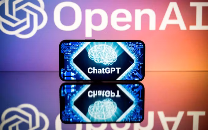 Hình ảnh ChatGPT hiển thị trên smartphone, đằng sau là logo của OpenAI. Ảnh: Reuters