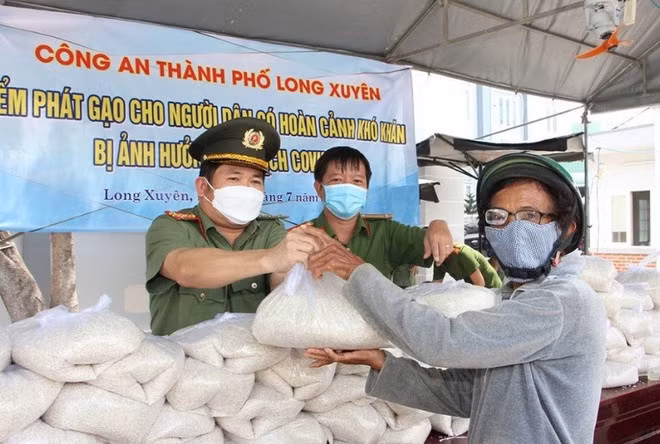 Đại tá Đinh Văn Nơi trao tặng gạo cho người dân gặp khó khăn trong dịch.