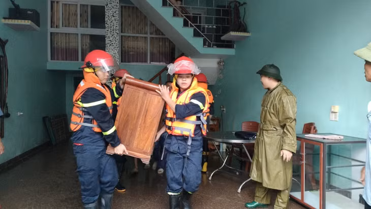 Lực lượng chức năng huyện Tiên Yên di chuyển đồ đạc cho các hộ dân có nhà bị ngập lụt