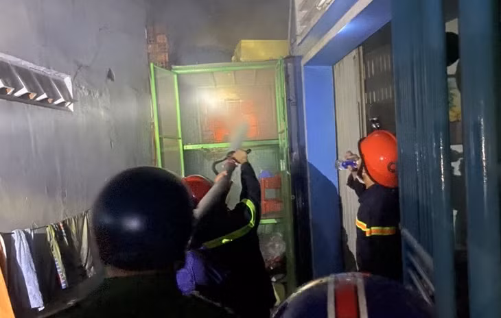 Cảnh sát phá tường để tiếp cận đám cháy. Ảnh: TS