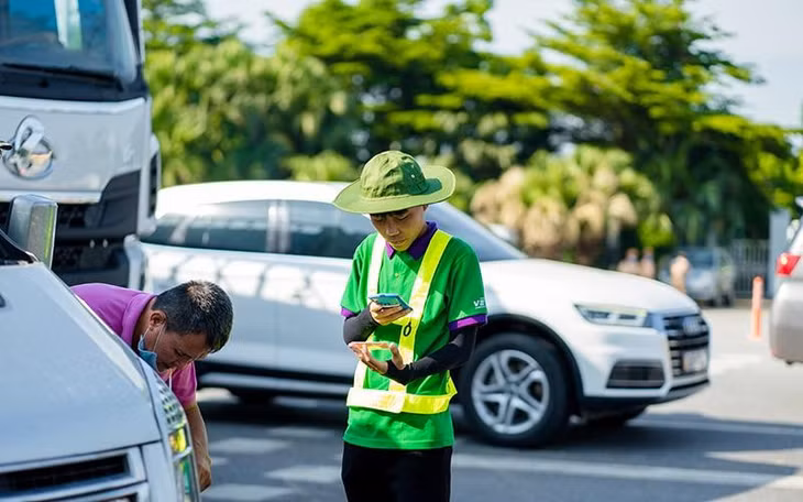 Nhân viên cung cấp dịch vụ ETC hướng dẫn, hỗ trợ khách hàng dán thẻ, nạp tiền vào tài khoản.