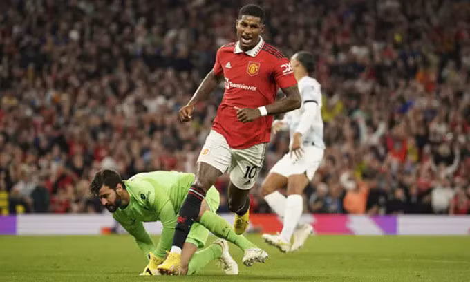 Rashford đánh bại Alisson trong tình huống ghi bàn thứ hai cho Man Utd. Ảnh: AP.
