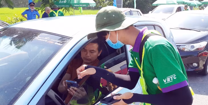 Nhân viên của đơn vị thu phí hướng dẫn người dân cách nạp tiền vào tài khoản.