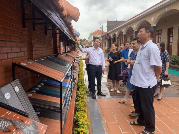 Đại diện công ty giới thiệu sản phẩm gốm cho các đại biểu.