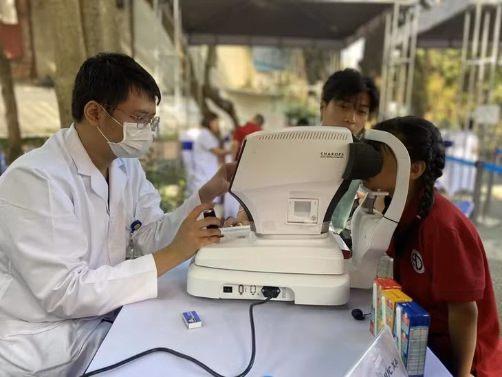 Bác sỹ khám mắt cho trẻ tại Trường Tiểu học Hoàng Diệu, Ba Đình, Hà Nội. (Ảnh: PV/Vietnam+)