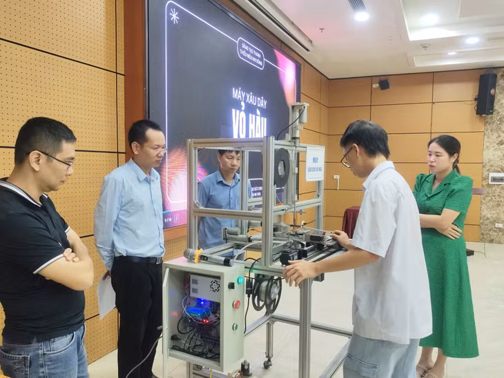 Học sinh Trường THPT Bạch Đằng, TX Quảng Yên, giới thiệu sản phẩm máy xâu dây vỏ hàu.