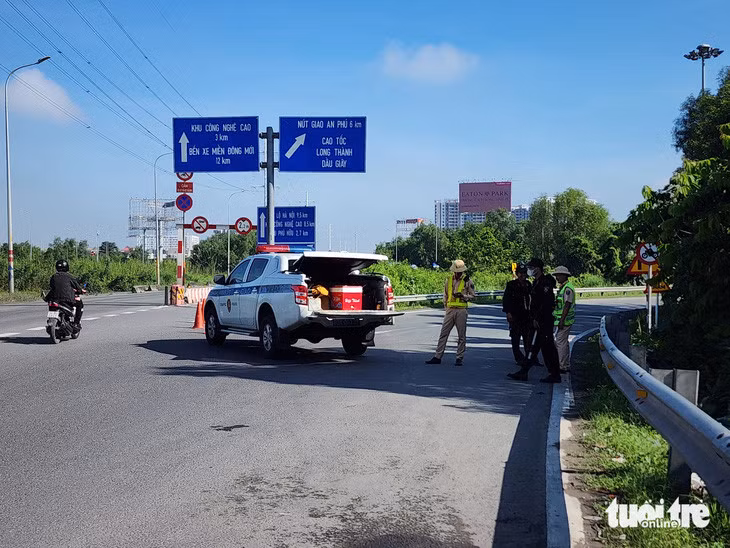 Lực lượng Cục Cảnh sát giao thông chặn lối vào cao tốc đoạn giao với đường Võ Chí Công, hạn chế xe lên cao tốc tránh ùn ứ kéo dài - Ảnh: MINH HÒA