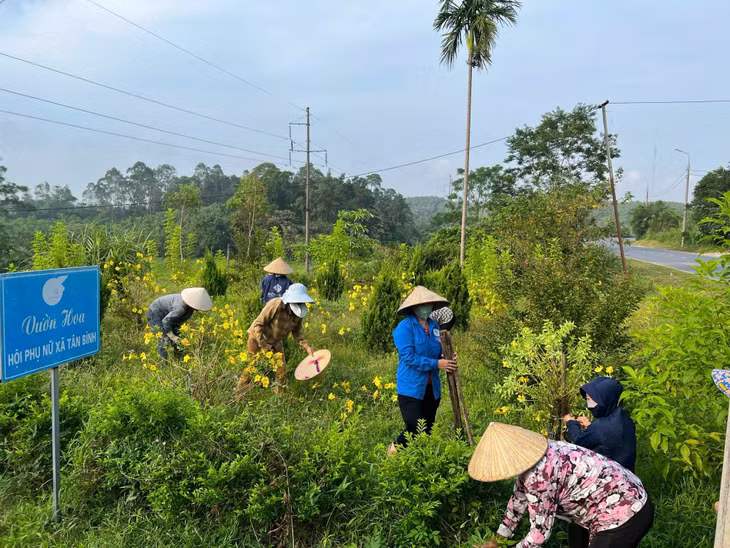 Chị em phụ nữ xã Tân Bình (huyện Đầm Hà) chăm sóc cây hoa, tạo cảnh quan xanh, sạch, đẹp.