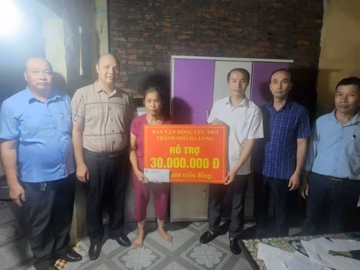 Đoàn công tác của thành phố trao tiền hỗ trợ cho hộ có nhà bị sập hoàn toàn do ảnh hưởng của cơn bão số 3.