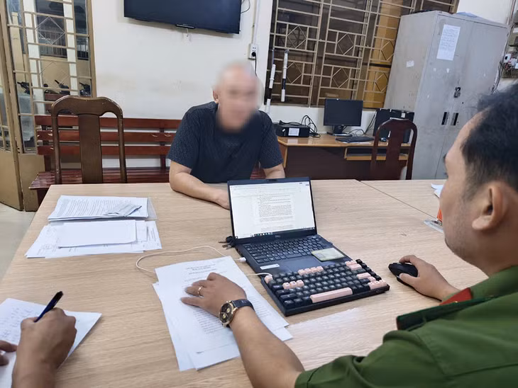 Công an làm việc với đối tượng N.A.T. Ảnh: Công an cung cấp