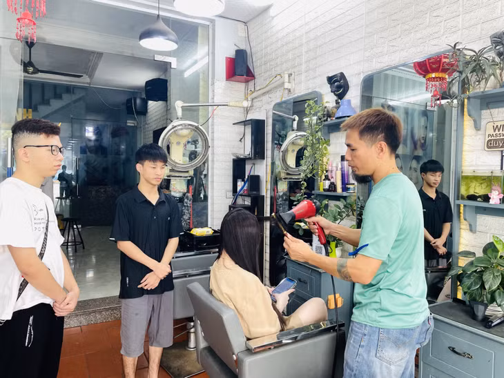 Trần Đức Minh (thứ 2, trái sang) bị khiếm thính được nhận làm tại salon tóc Duy Anh (TP Hạ Long).