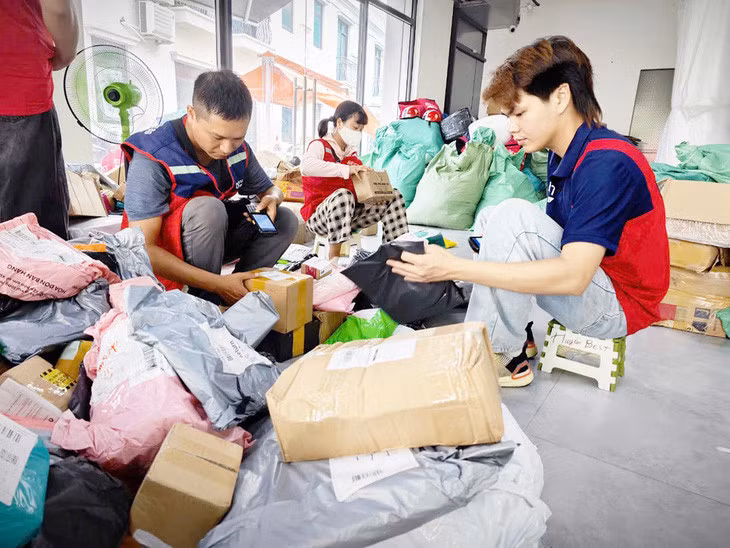 Hàng hóa từ Trung Quốc chất đầy tại bưu cục, nhân viên phân loại địa chỉ để giao hàng - Ảnh: CÔNG TRUNG
