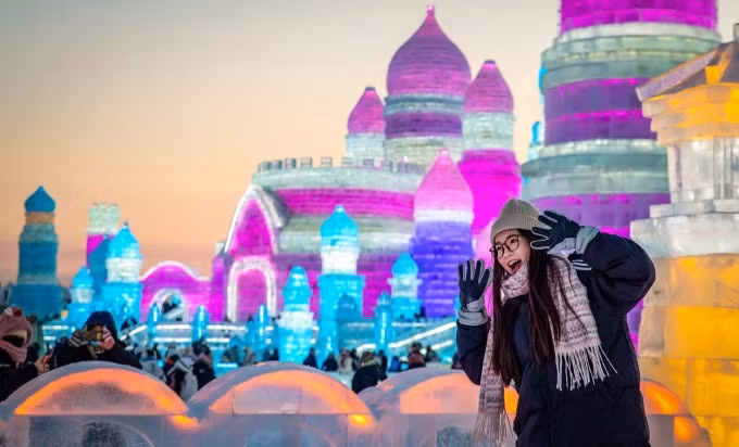 Du khách check in bên tác phẩm điêu khắc từ băng. Ảnh: Xinhua