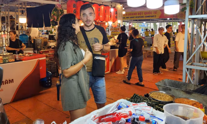 Maria và bạn trai tìm kiếm các món ăn Việt trong lễ hội tối 23/10. Ảnh: Bích Phương