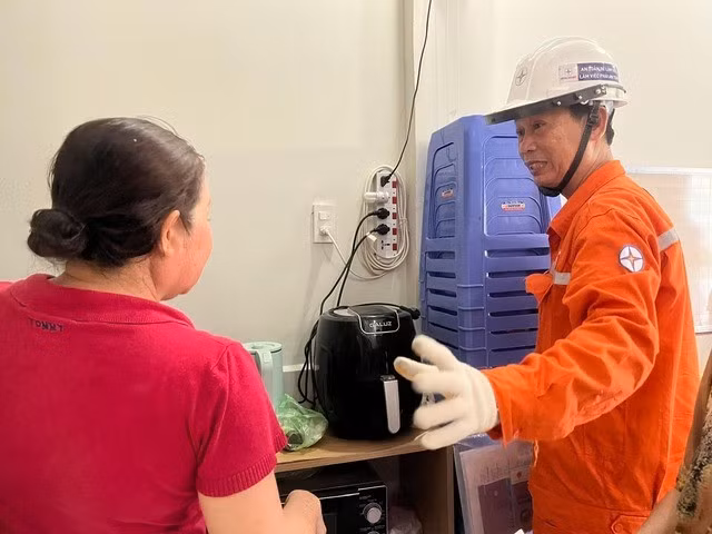 Nhân viên điện lực TP HCM hướng dẫn người dân cách tiết kiệm điện sinh hoạt. Ảnh: THANH NHÂN.