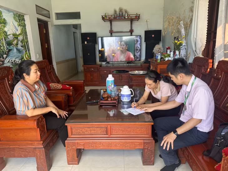 Cán bộ Ngân hàng CSXH TX Quảng Yên hướng dẫn người dân hoàn thiện hồ sơ khoanh nợ.