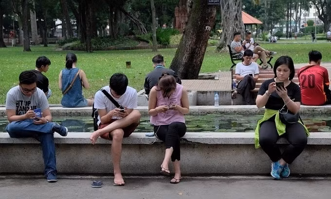 Người trẻ Việt dùng điện thoại trong Công viên Tao Đàn, TP.HCM, năm 2019. Ảnh: Shutterstock/Anh Huy