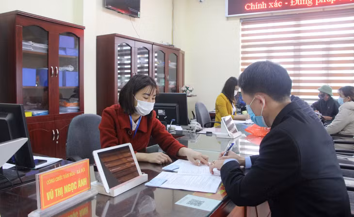 Cán bộ Bộ phận tiếp nhận và trả kết quả hiện đại phường Hồng Hà (TP Hạ Long) hướng dẫn công dân làm thủ tục hành chính. Ảnh: Thu Chung