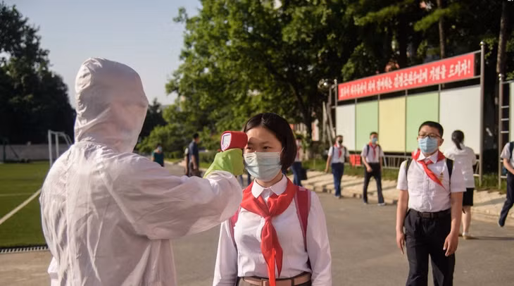 Một học sinh được đo nhiệt độ trước khi vào trường trung học tại Bình Nhưỡng trong tháng 6/2021. Ảnh: AFP.