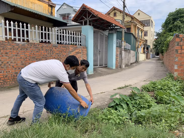 Cán bộ Trung tâm Y tế thị xã Đông Triều hướng dẫn người dân xử lý các ổ bọ gậy, ngăn không cho muỗi đẻ trứng.