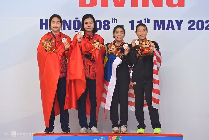 Hồng Hạnh (trái) - Phương Mai cùng đứng trên bục nhận huy chương với đôi giành HC vàng người Malaysia Ng Yan Yee - Ong Ker Ying. Ảnh: Giang Huy