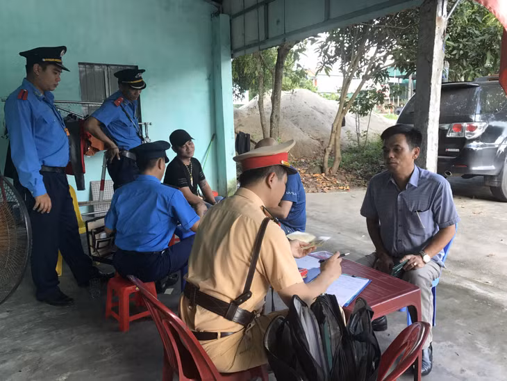 Cán bộ Đội CSGT số 2 (Phòng CSGT đường bộ, đường sắt) lập biên bản xử lý vi phạm hành vi không đội MBH khi tham gia giao thông bằng xe mô tô.