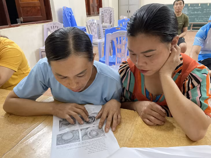 Chị Lỷ Thị Mai (bên phải) cùng học viên tìm hiểu kiến thức về trồng rau quả an toàn.