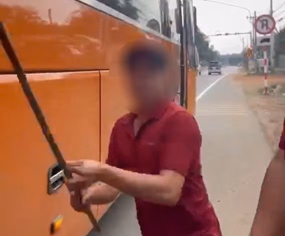 Người của xe khách hùng hổ cầm gậy dọa đánh người dân khi bị phản ánh. Ảnh cắt từ clip bạn đọc cung cấp