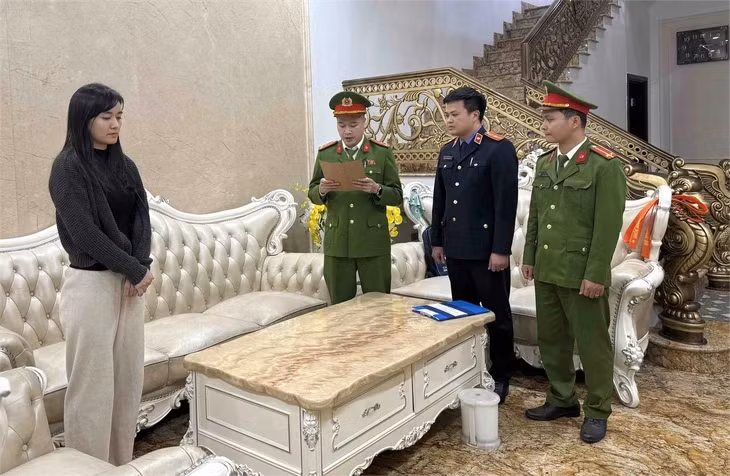 Cơ quan công an tống đạt quyết định khởi tố bị can, bắt tạm giam đối với Nguyễn Thu Nga - Ảnh: CTV