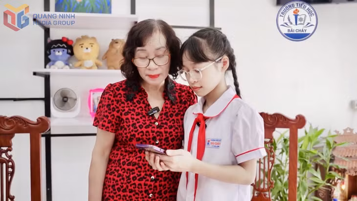 Học sinh Đặng Tiểu Anh, lớp 5A11 (Trường Tiểu học Bãi Cháy) hướng dẫn người thân các kỹ năng sử dụng điện thoại thông minh thông qua việc tham gia mô hình "Ông bà học tập số cùng con cháu”.