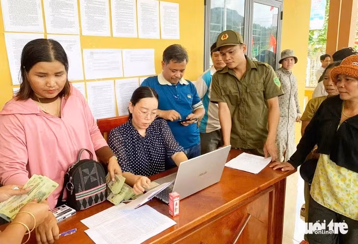 Người dân nhận quà Chính phủ tặng nhân dịp mừng 80 năm Quốc khánh và 50 năm thống nhất đất nước - Ảnh: TTO