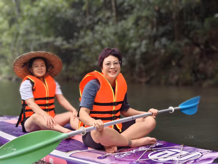 Khách du lịch trải nghiệm hoạt động chèo sup ở suối khi đến Am Váp Farm Kỳ Thượng. Ảnh: Đơn vị cung cấp.
