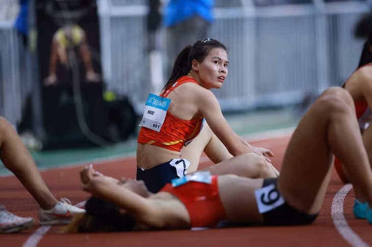 Nguyễn Thị Ngọc ngồi xem bảng thành tích, trong khi người đồng đội Hoàng Thị Minh Hạnh nằm nghỉ - Ảnh: LINH ĐÔNG