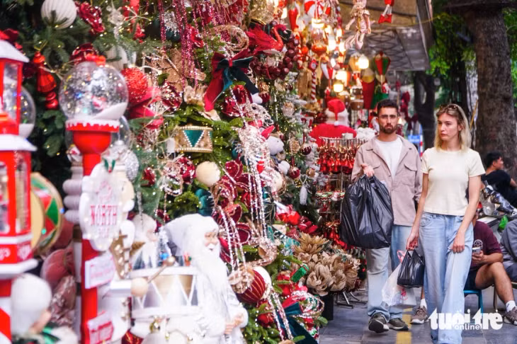 Nhiều du khách nước ngoài dạo phố, mua sắm đồ để trang trí Noel - Ảnh: PHẠM TUẤN