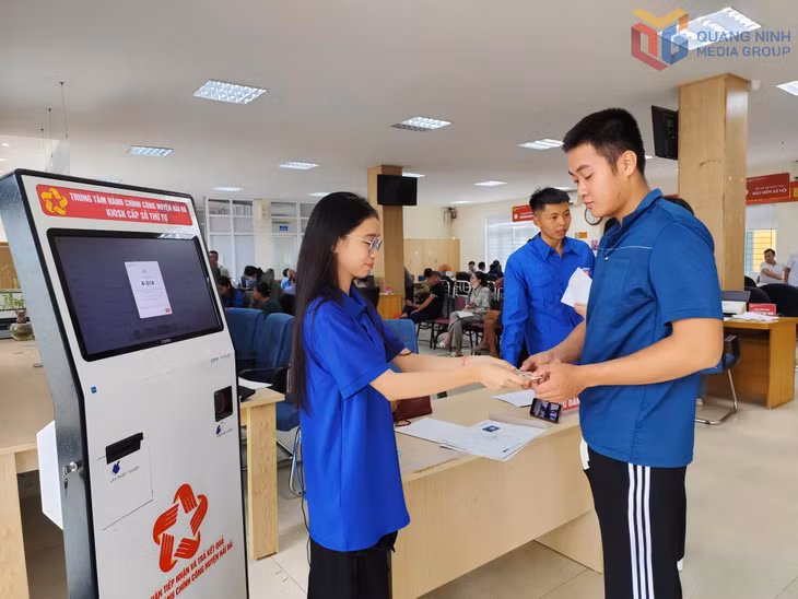 ĐVTN xã Quảng Đức hướng dẫn người dân lấy số làm TTHC tại Trung tâm HCC xã Quảng Đức.