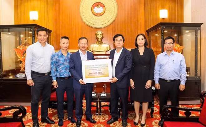 Ông Nguyễn Hồng Minh - Trưởng đoàn thể thao Việt Nam tại SEA Games 33 trao số tiền 116,5 triệu đồng ủng hộ đồng bào bị bão lũ tại Ủy ban Mặt trận Tổ quốc Việt Nam. Ảnh: Bùi Lượng