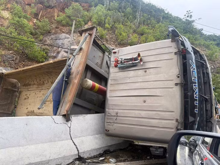 Chiếc xe tải đang chạy theo hướng từ Nha Trang ra sân bay Cam Ranh thì bất ngờ mất lái, sau đó tông vào dải phân cách, lật nhào khiến giao thông tê liệt. Ảnh: Phùng Thế Quang