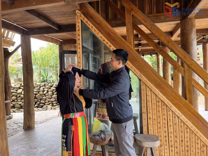 Du khách trải nghiệm mặc trang phục truyền thống người dân tộc Dao tại khu du lịch Kỳ Thượng Am Váp.