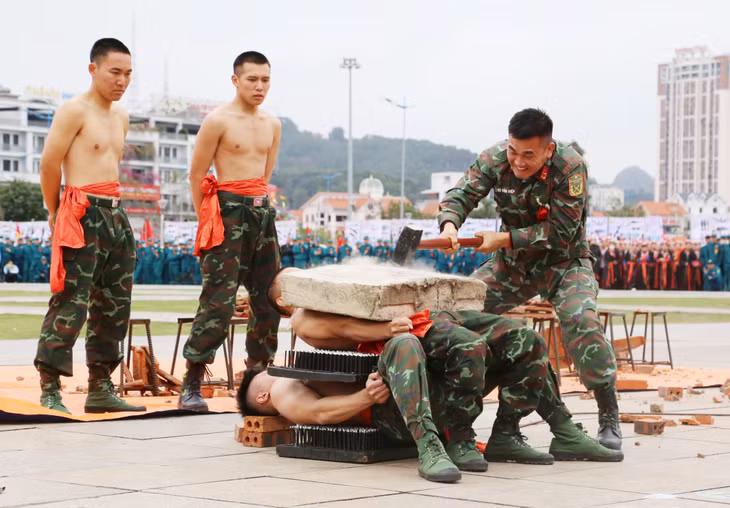 2024-03_Lễ ra quân huấn luyện năm 2024- Màn nằm trên bàn chông và công phá khối bê tông trên bụng. Ảnh: Nguyễn Thanh