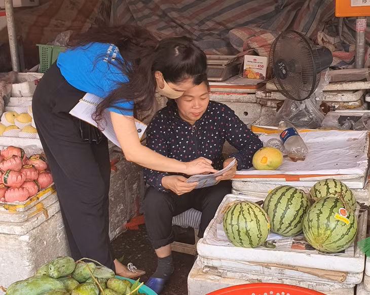 Nhân viên BHXH huyện Hải Hà tuyên truyền, hướng dẫn các tiểu thương chợ trung tâm Hải Hà 2 (huyện Hải Hà) tham gia BHXH tự nguyện.