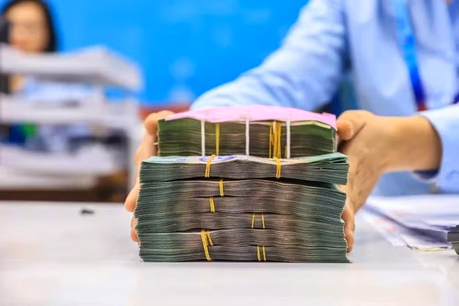 Mặc dù lãi suất huy động giảm nhưng lượng tiền gửi vào ngân hàng vẫn tăng. (Ảnh: Vietnam+)
