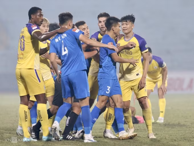 Thành Chung (áo vàng phải) nổi cáu với Tăng Tiến (số 4) sau pha phạm lỗi với Tuấn Hải. Ảnh: Hiếu Lương