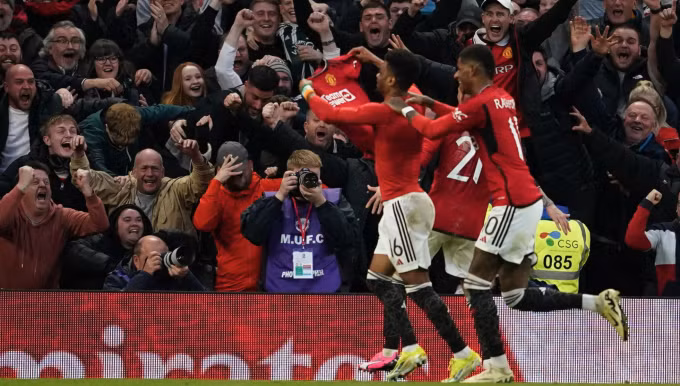 Amad Diallo cởi áo, chia vui với CĐV Man Utd sau khi ghi bàn ấn định kết quả trận đấu. Ảnh: AP