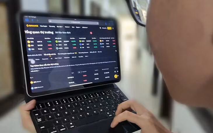 Khách hàng theo dõi tiền ảo trên sàn giao dịch tiền điện tử Binance. (Ảnh ĐĂNG ANH)
