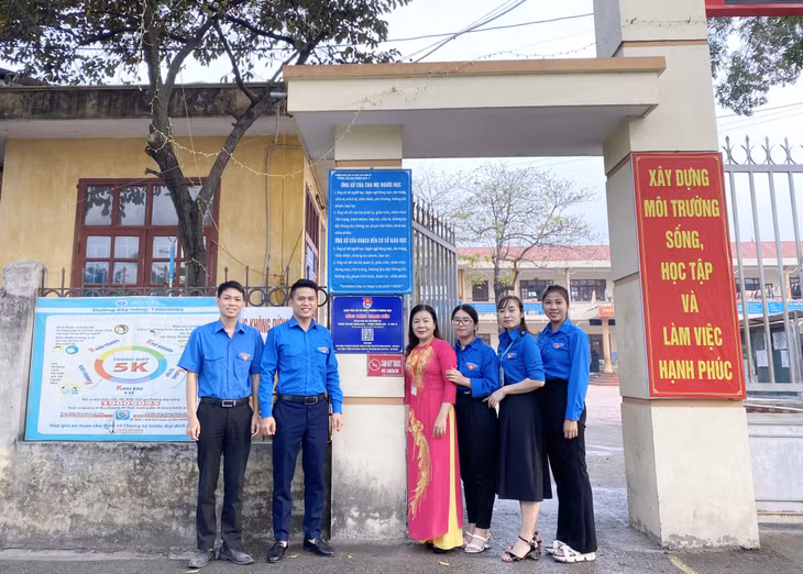 Anh Đỗ Thái Sơn (thứ 2, trái sang) và các ĐVTN phường Phương Nam thực hiện gắn bảng mã QR-Code tích hợp thông tin của Trường Tiểu học Phương Nam A.