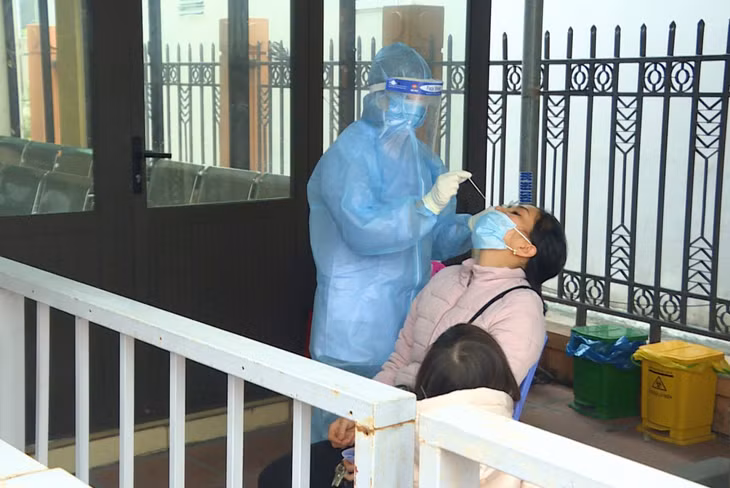 Nhân viên Trạm Y tế phường Cẩm Thủy (TP Cẩm Phả) test nhanh Covid-19 cho người dân.